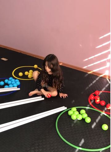 Renkli toplarla eşleme çalışması yapan çocuk