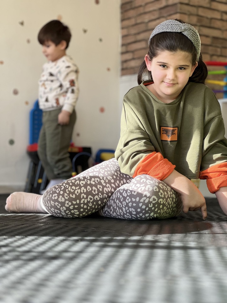 Eğitim alanında minder üzerinde oturan çocuk